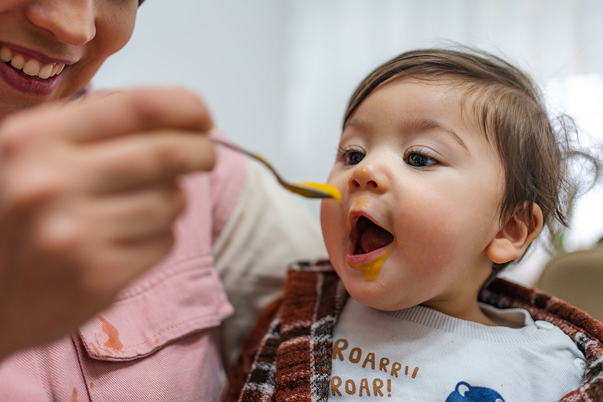 Baby eagerly eating from a spoon