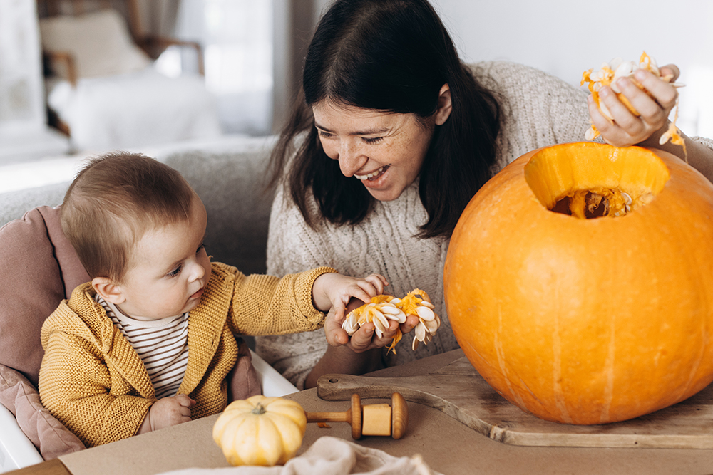 Mother and baby carving a pumpkin together