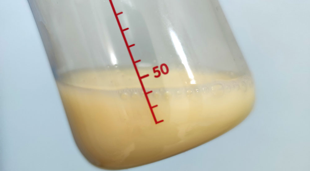 Close-up of a bottle showing a small amount of expressed colostrum