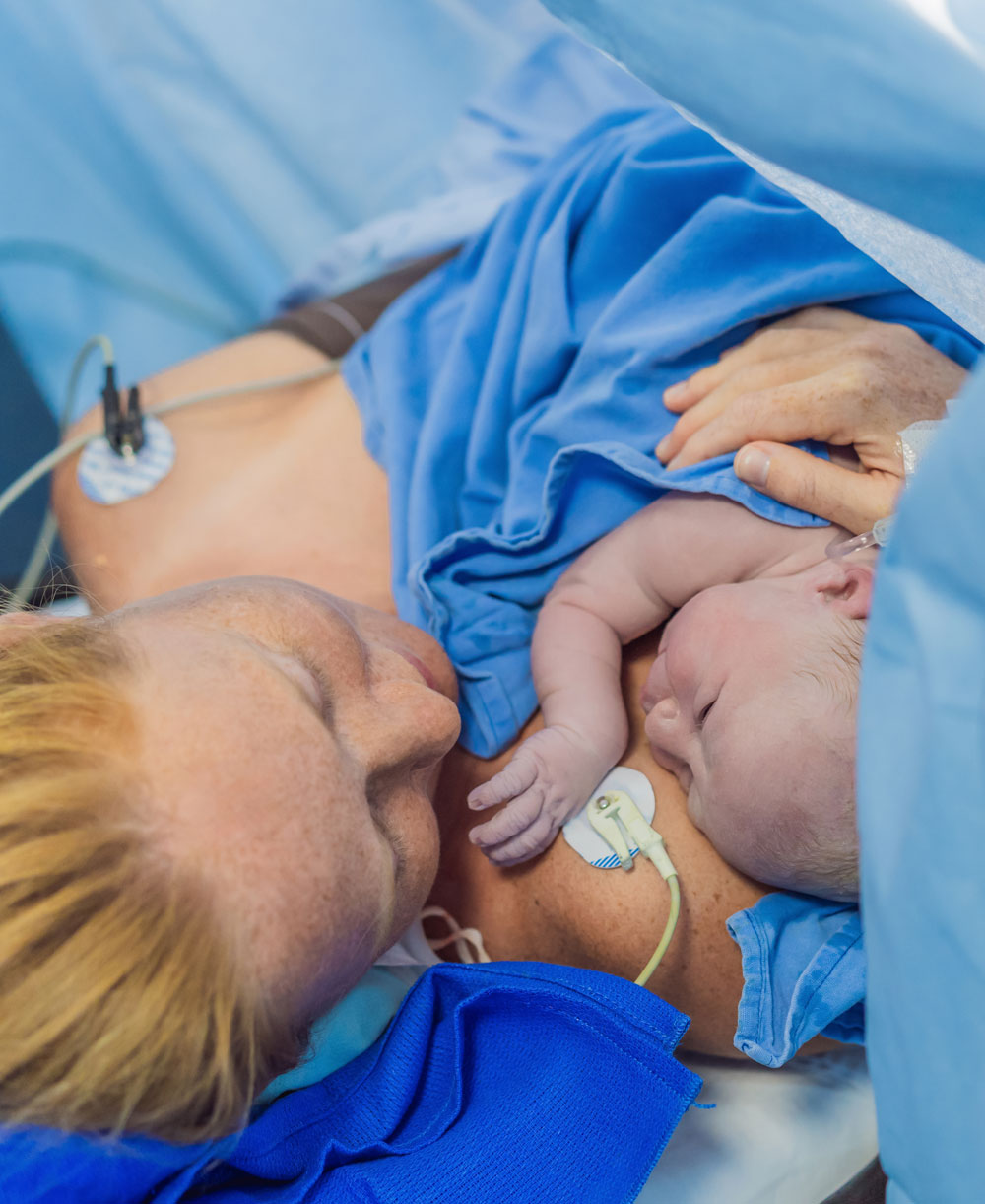 Mother holding her newborn skin-to-skin after delivery