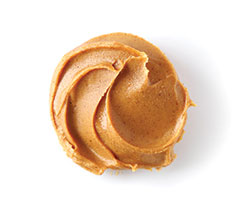 Smooth peanut butter swirl on white background.