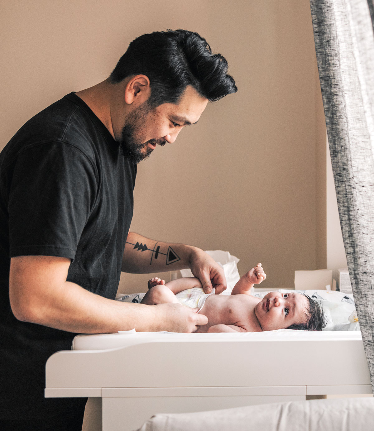 Father changing baby's diaper on a changing table