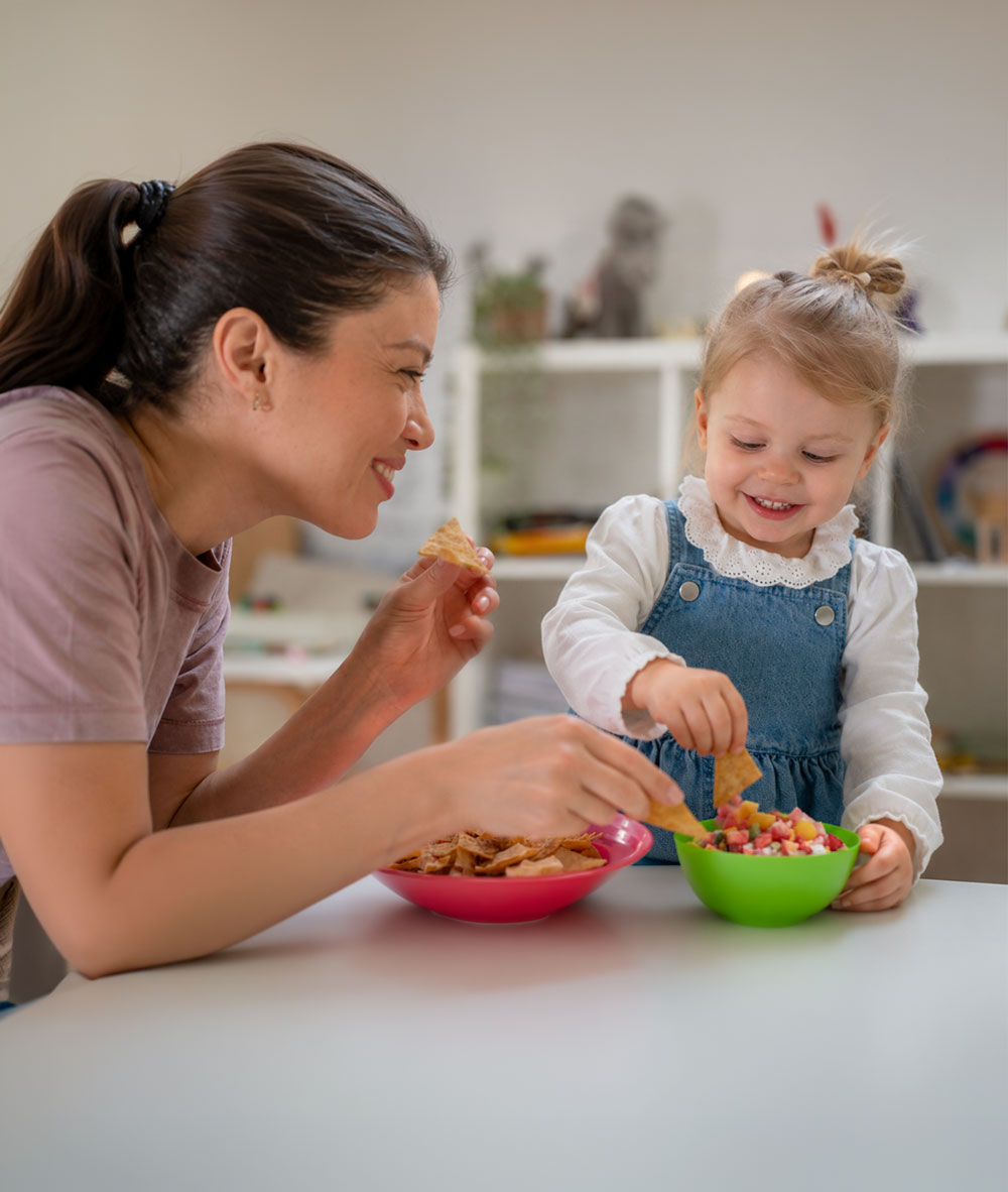 Mother and toddler sharing a snack joyfully