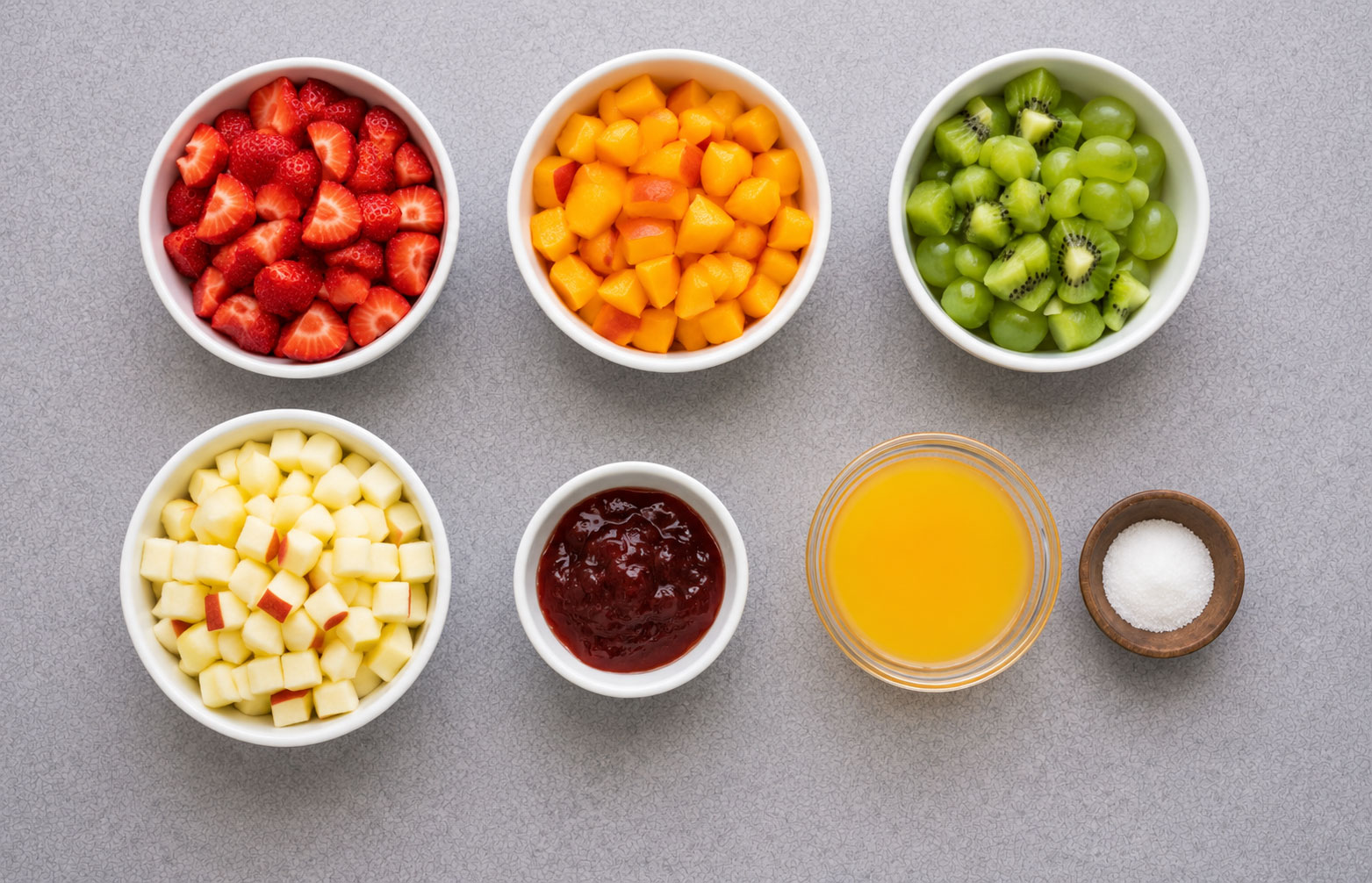 Bowls of chopped fruit and condiments on table
