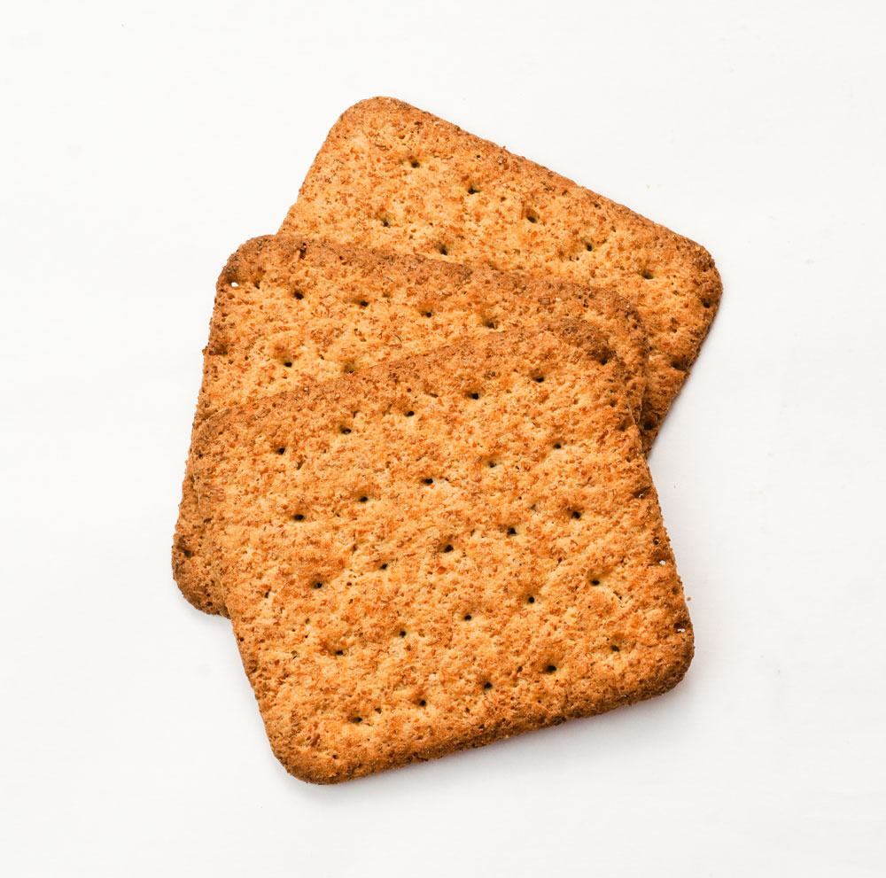 Stacked whole wheat crackers on white background